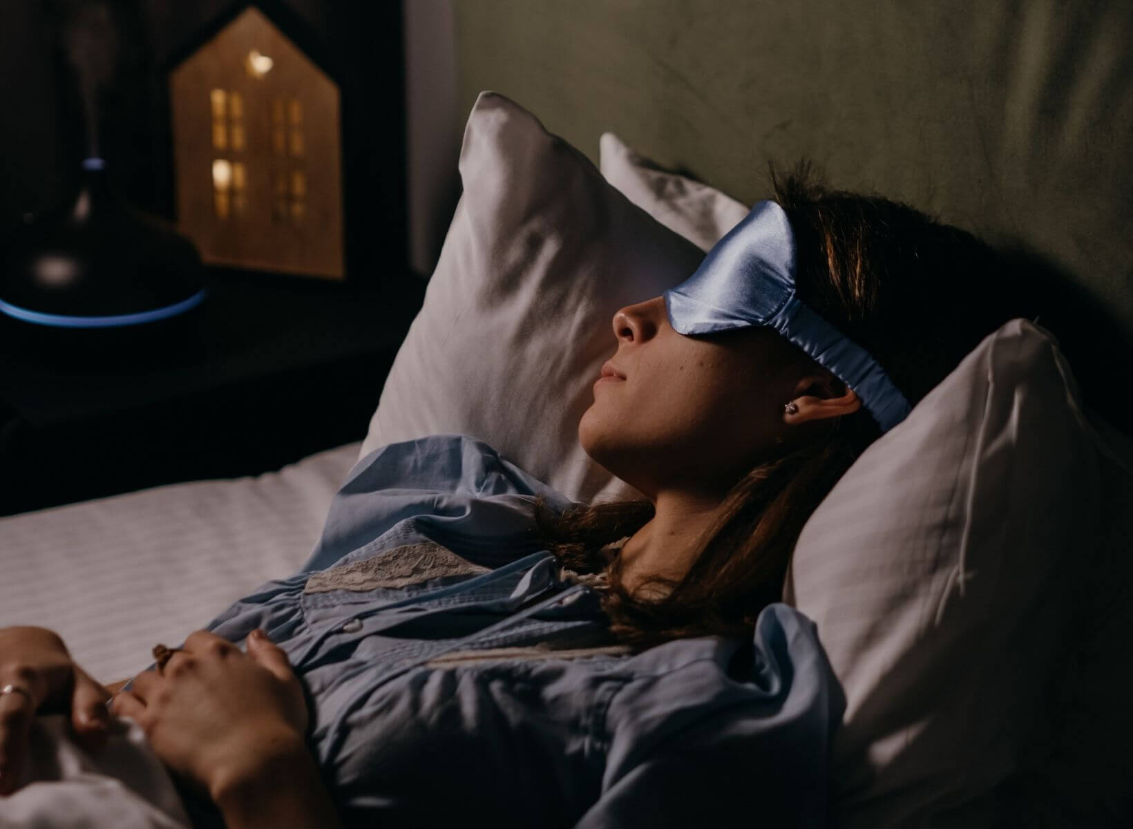 A woman sleeping in bed with an eye mask over her eyes