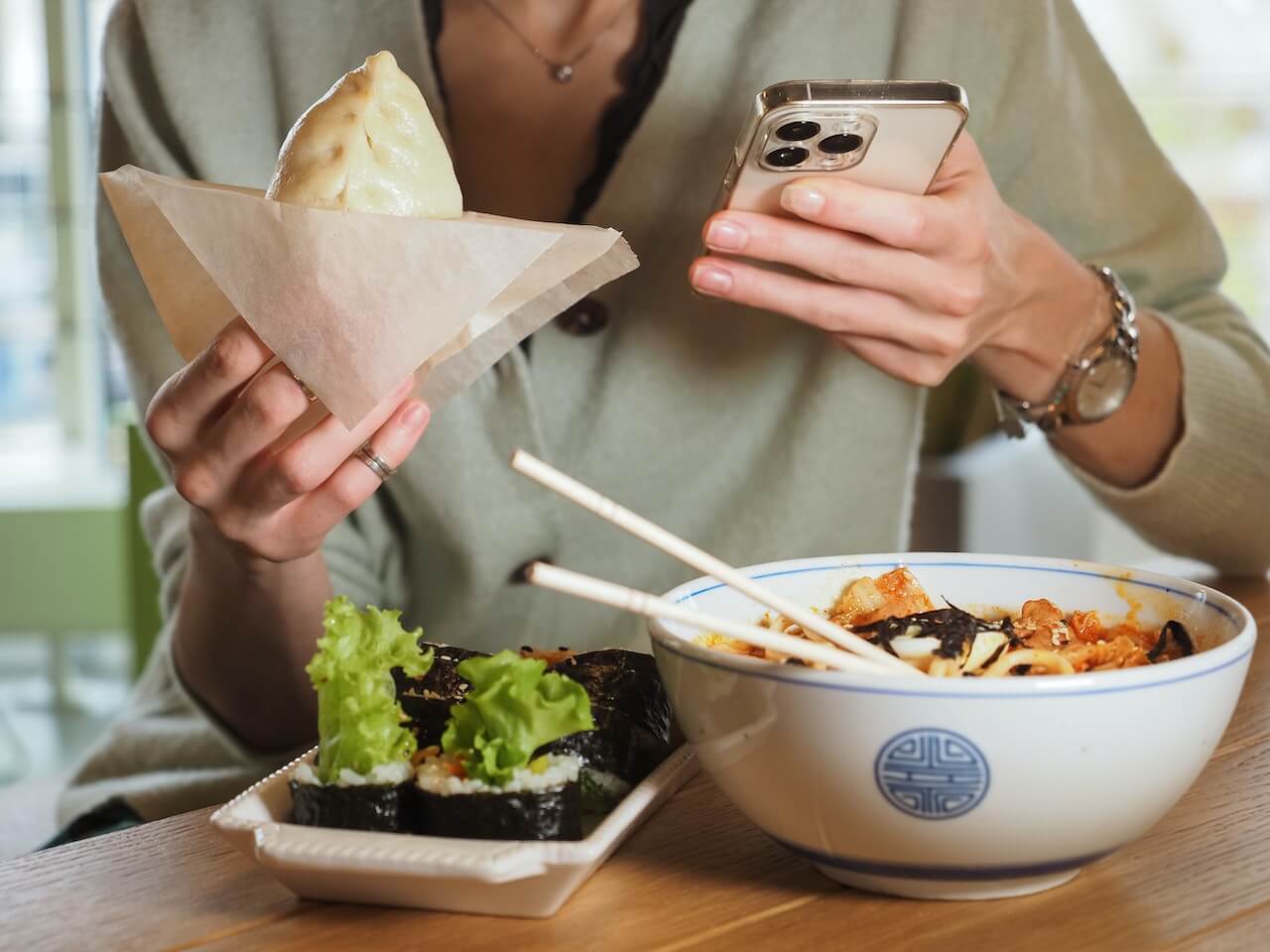 Womans-hands-using-phone-while-eating-a-lot