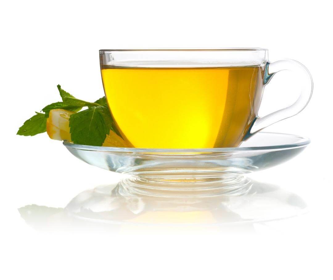 glass of green tea on a saucer with a slice of lemon