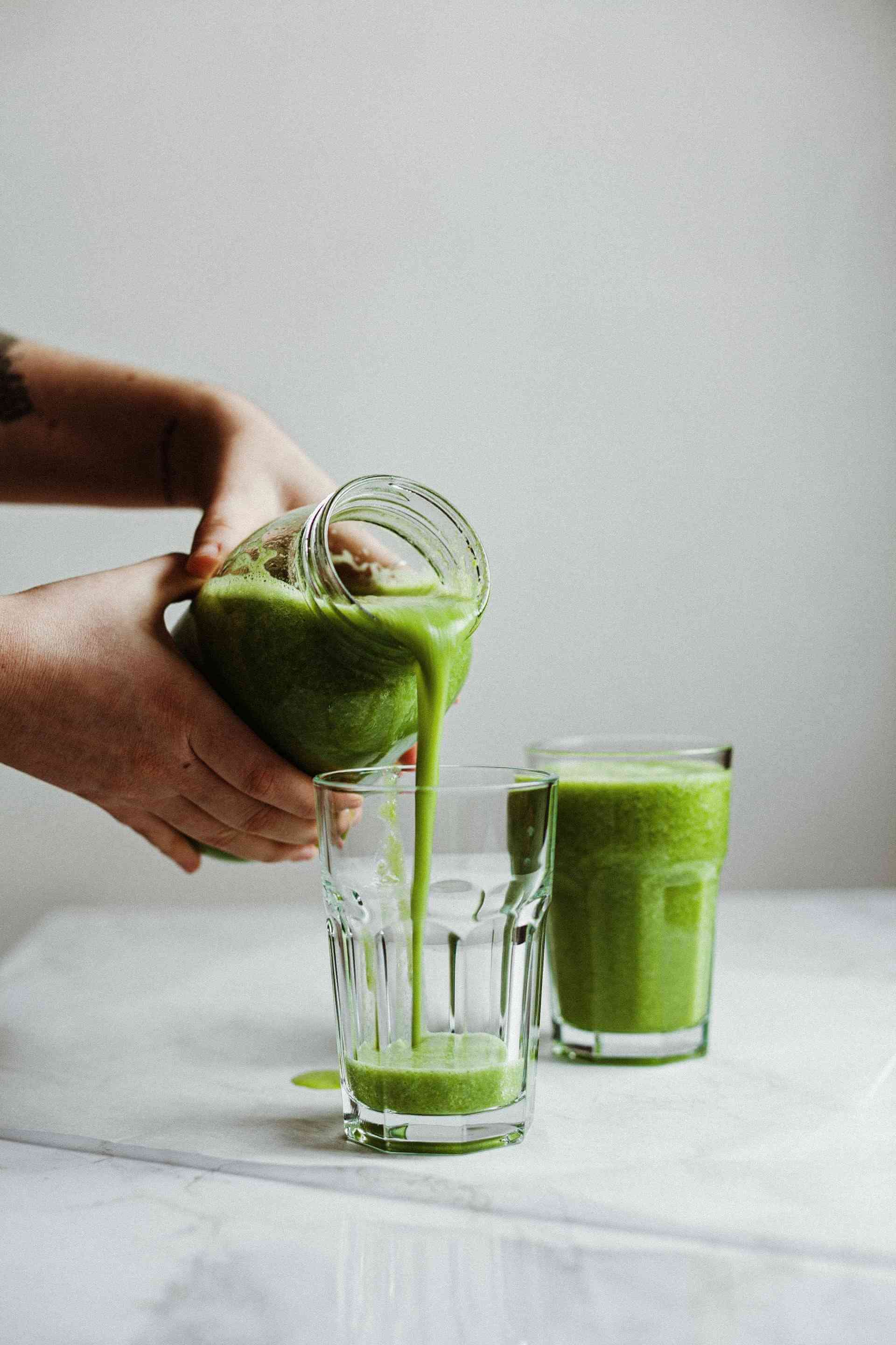 Womans-hands-pouring-celery-juice-on-two-glasses