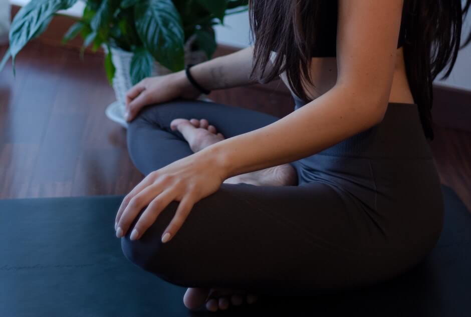 Woman sitting cross-legged and meditating in studio