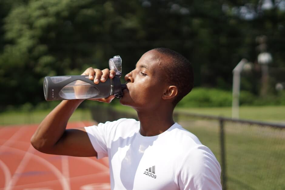 Man drinking water on running track