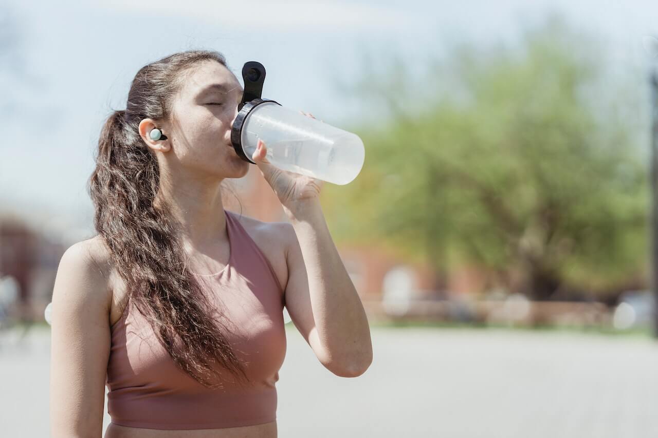 woman drinking water to avoid dehydration