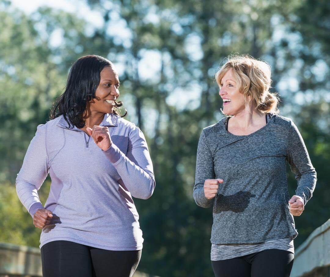 two women walking outdoors and talking