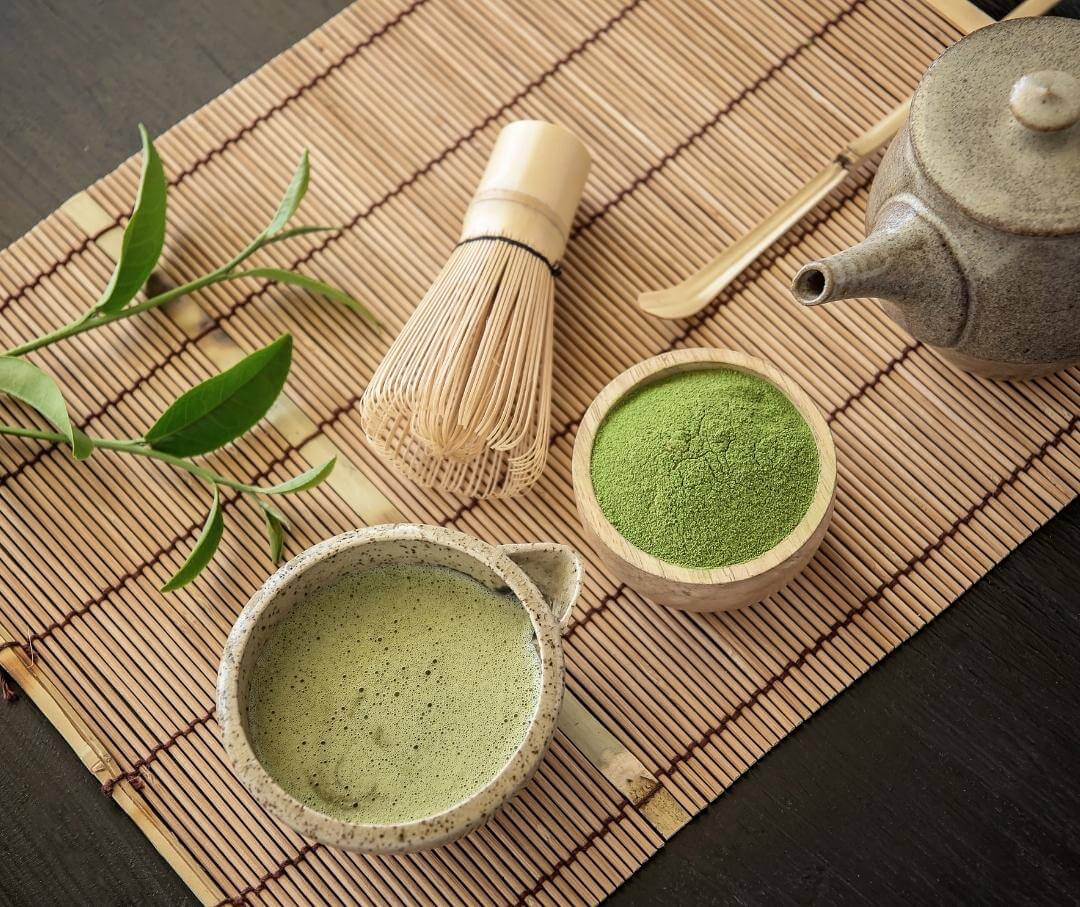 matcha powder and prepared matcha with serving implements