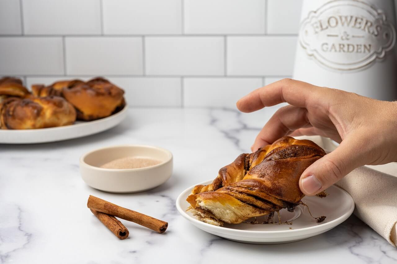 Close-up-of-hand-grabbing-chocolate-baked-bread-with-sugar-and-cinnamon