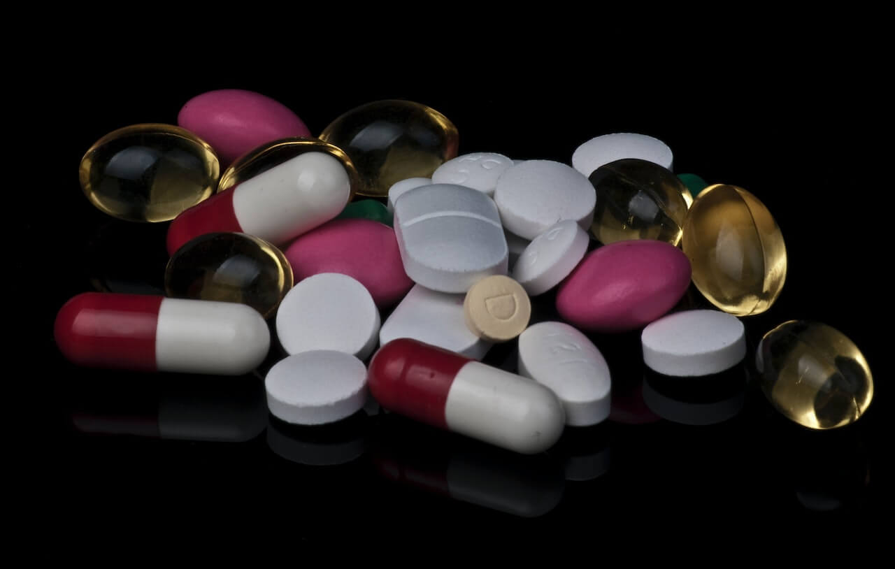 bunch-of-pills-on-black-surface