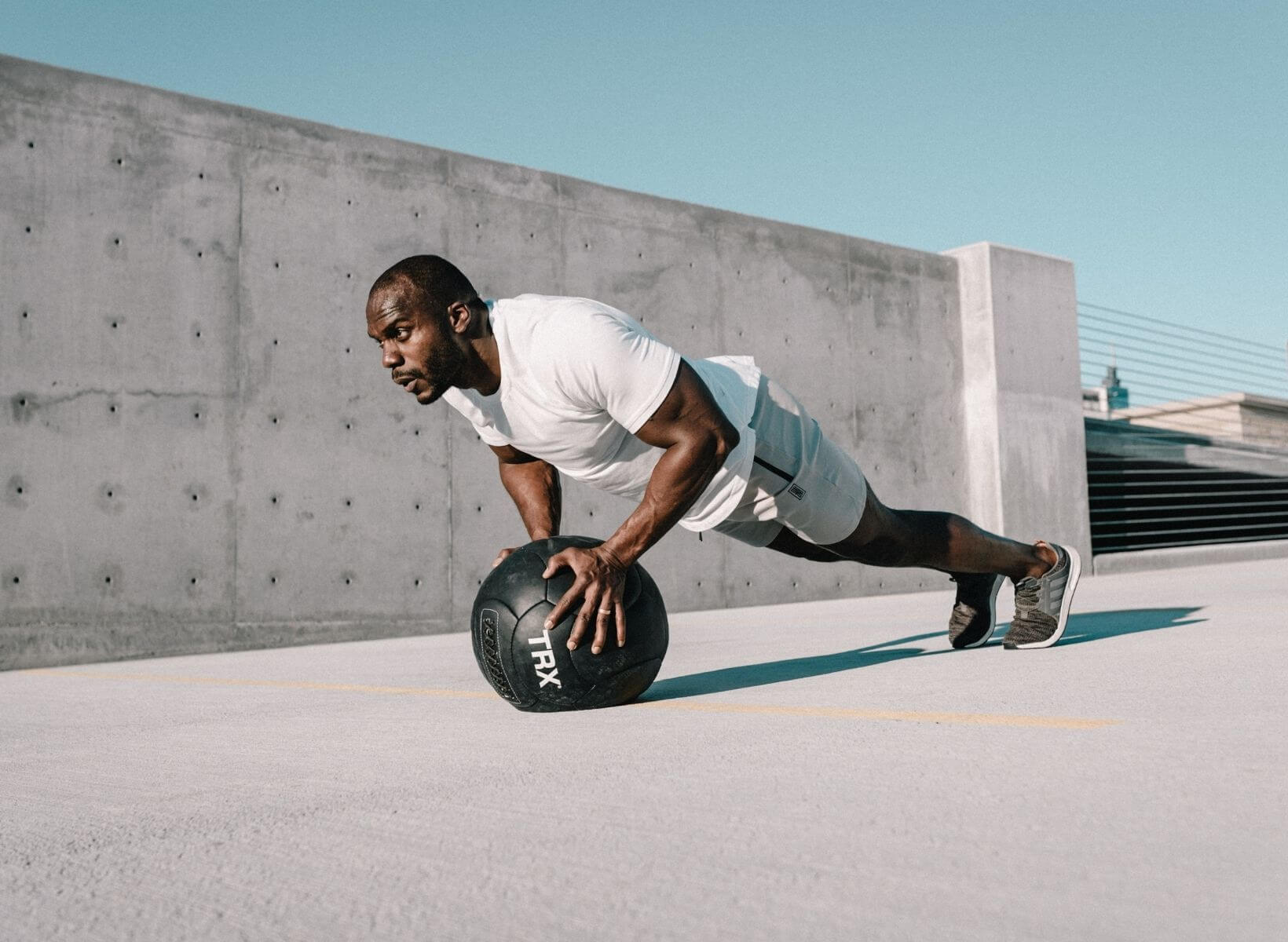 man doing a push-up on a medicine ball. He's exercising to lower blood sugar.