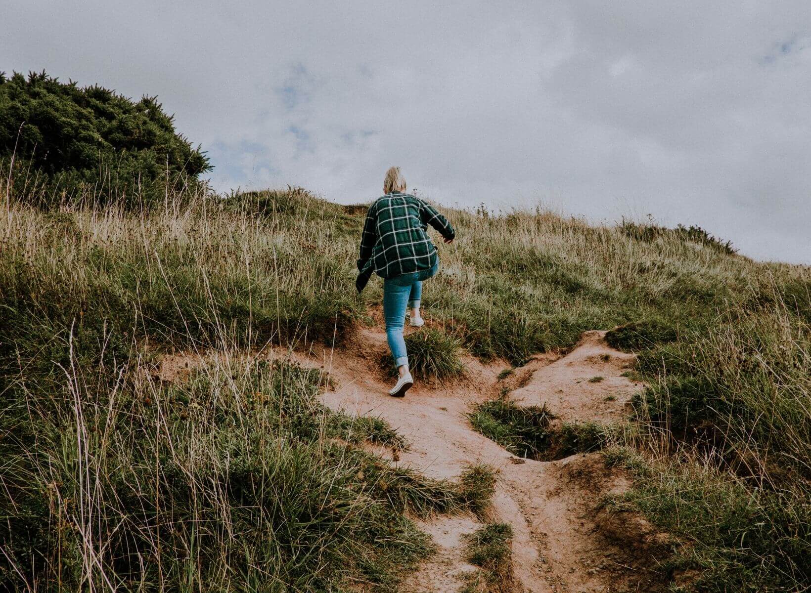 a woman climbing up a hill, a metaphor for a weight loss plateau