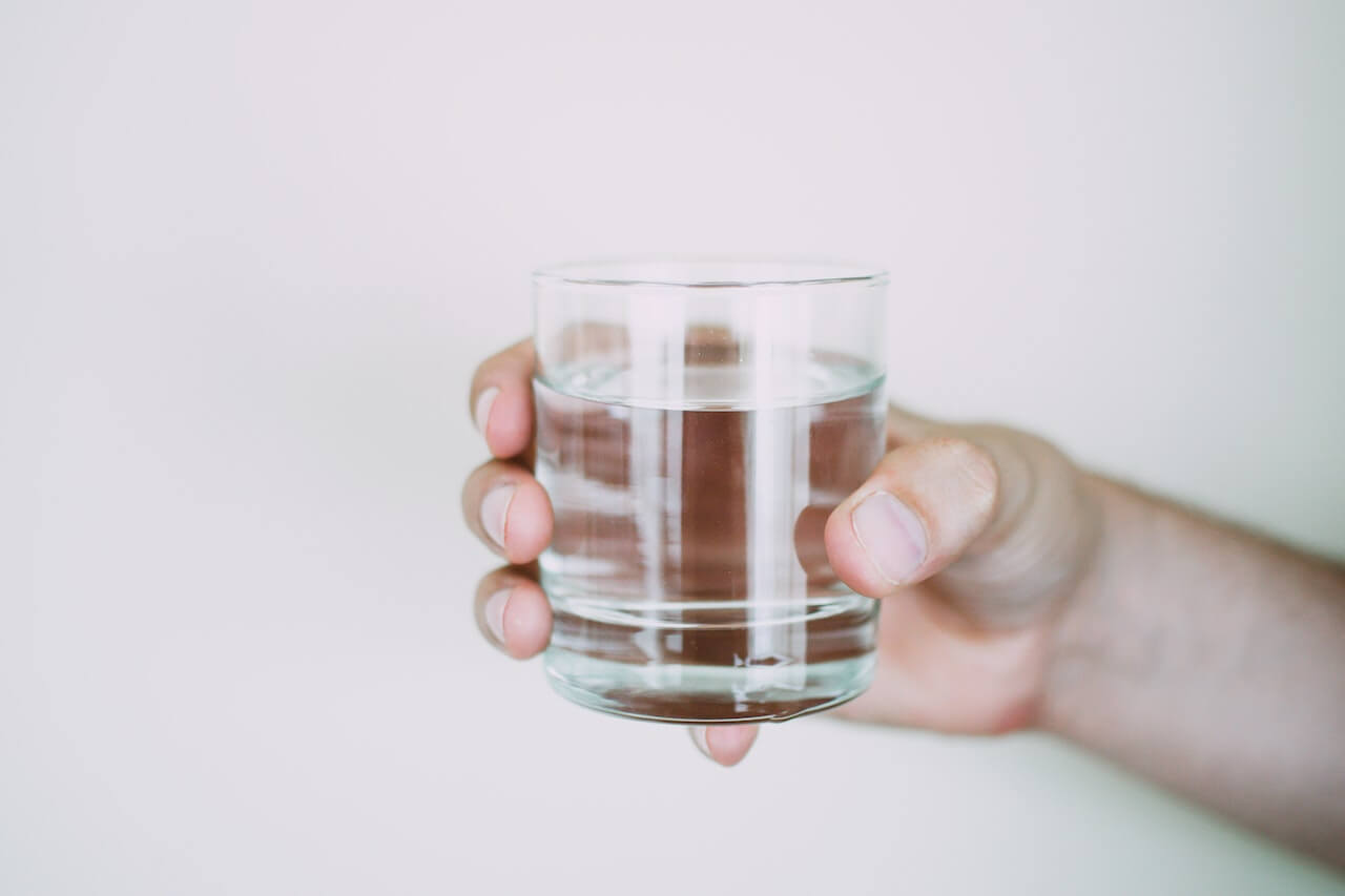 Person holding a glass of water.