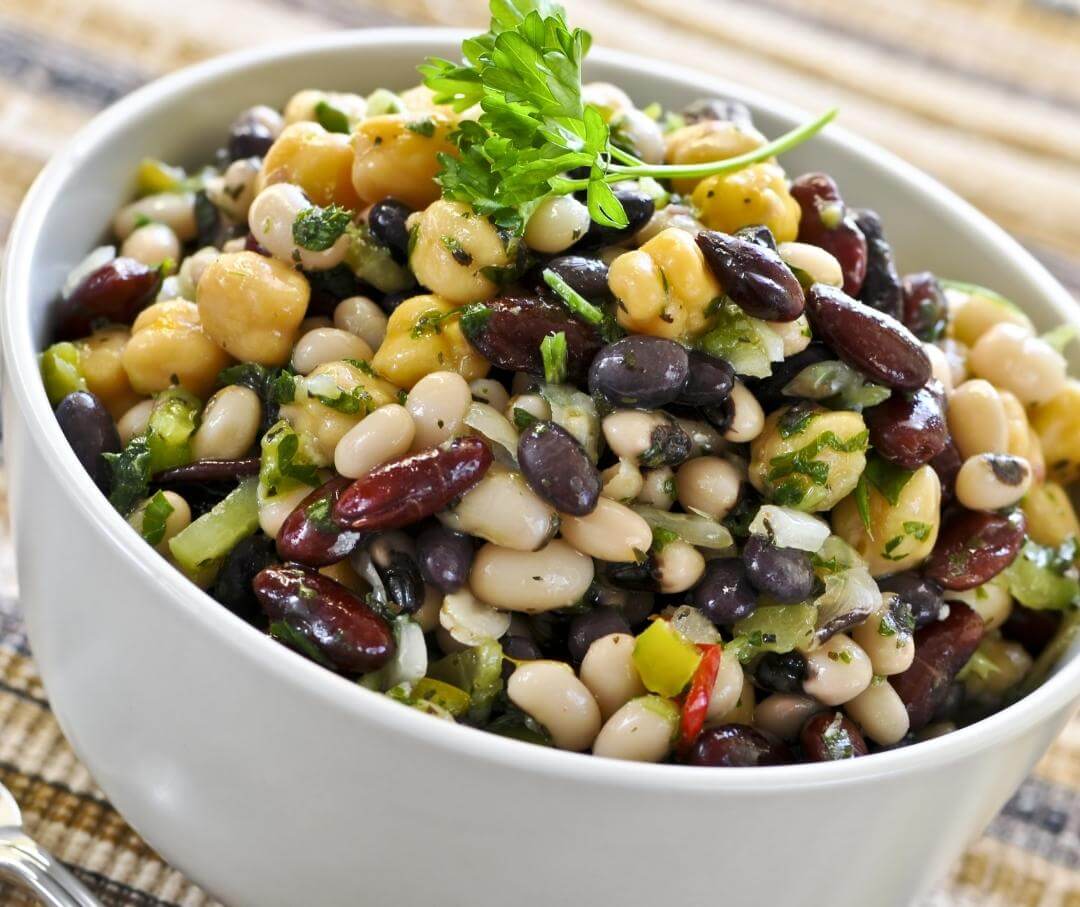 a bowl of bean salad garnished with parsley