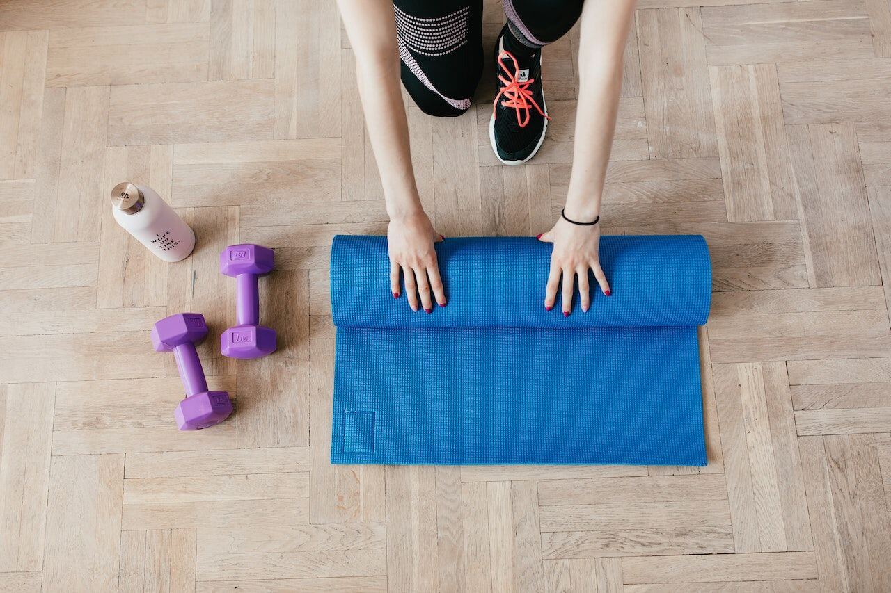 woman-folding-yoga-mat