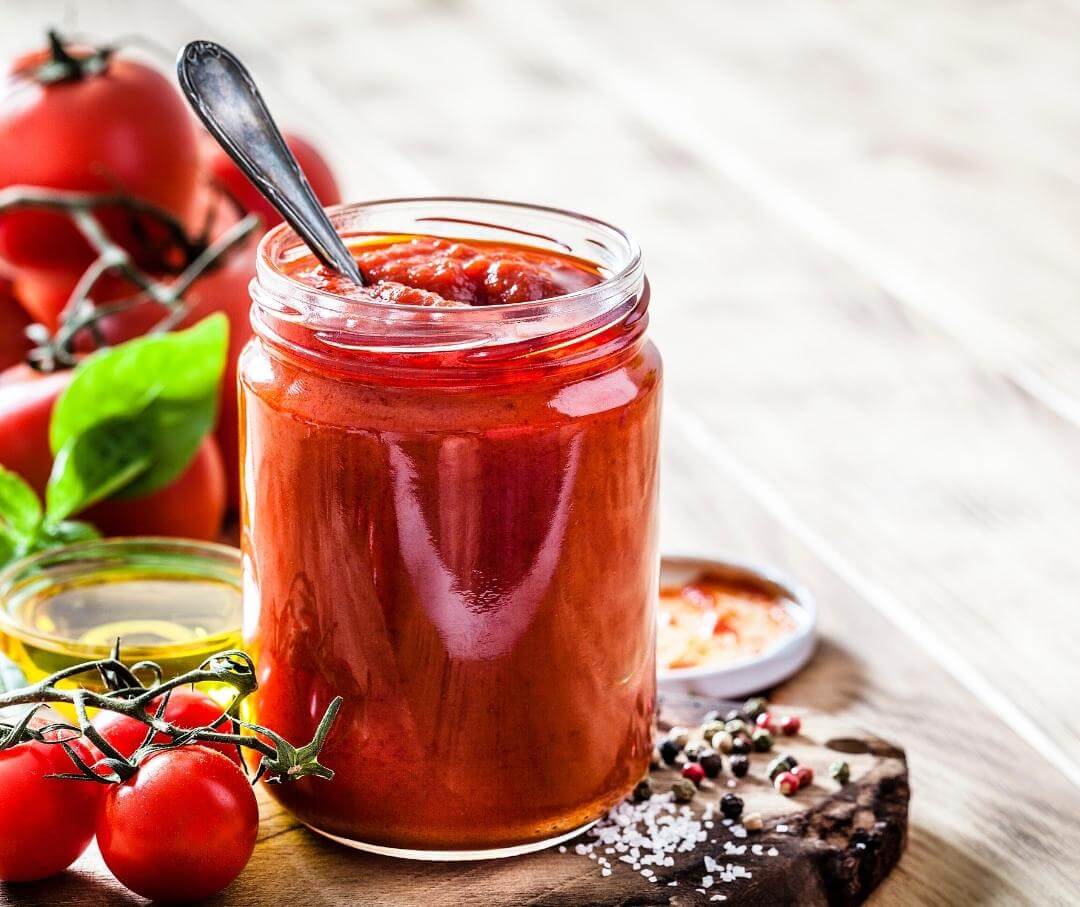 a jar of tomato sauce with a spoon in it