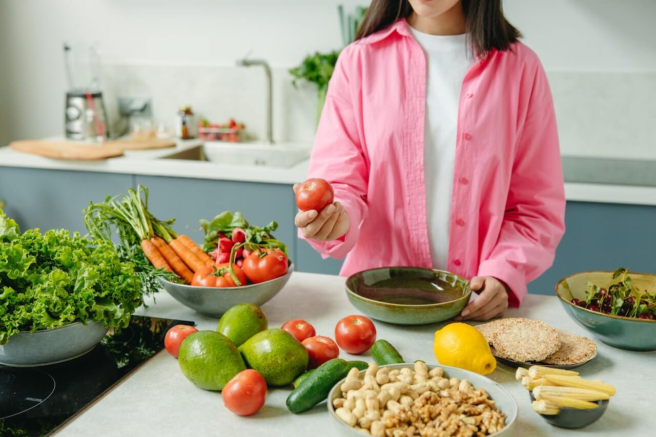 woman with a variety of food ingredients on a table