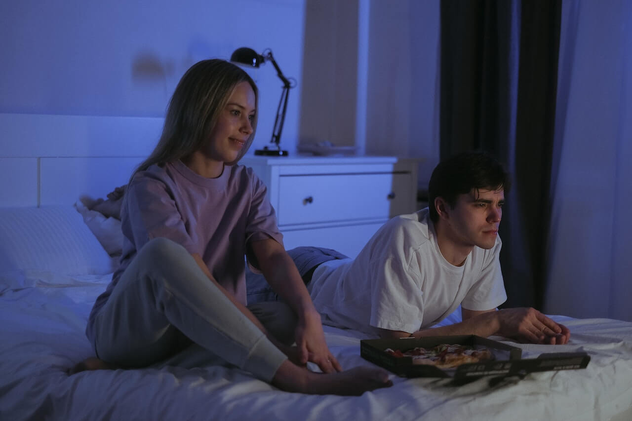 Couple eating pizza at night