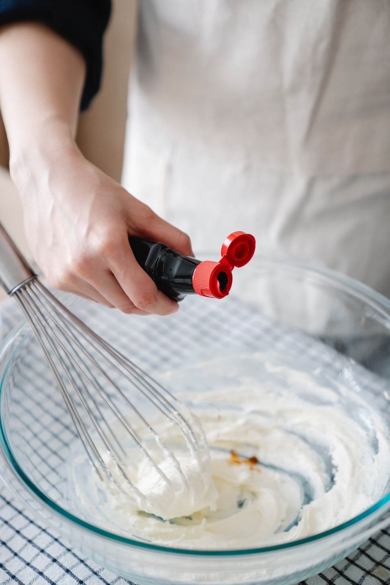 Man-adding-vanilla-extract-from-the-bottle-to-baking-recipe