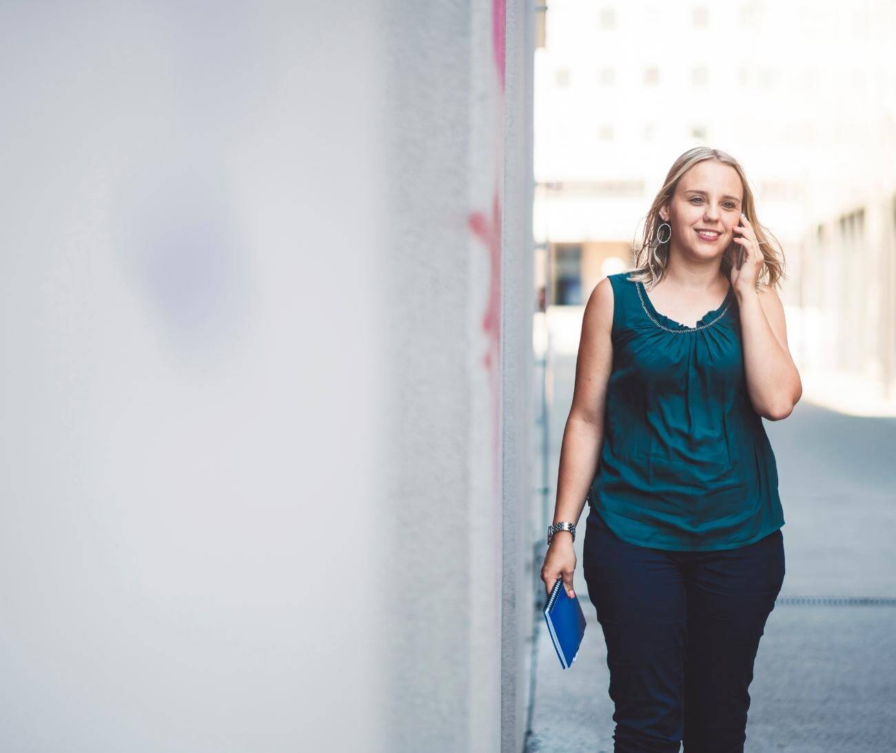 Woman walking down city street while talking on phone