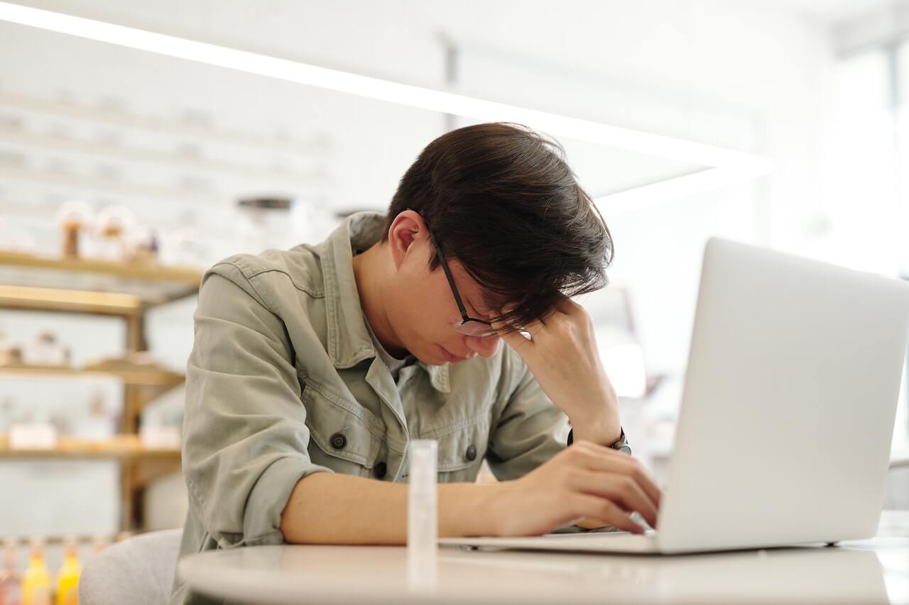 man having a headache while working on his laptop