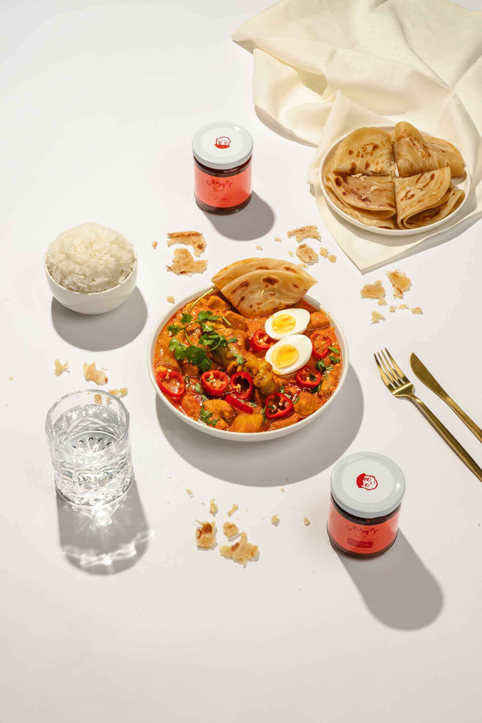 Mediterranean-meal-on-counter-with-glass-of-water-and-rice-and-pita-bread-on-the-sides