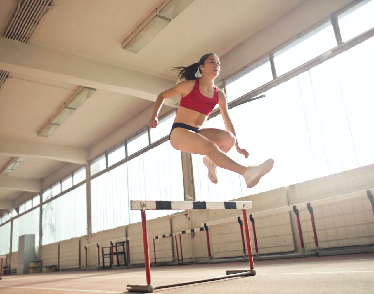 Woman running with hurdles