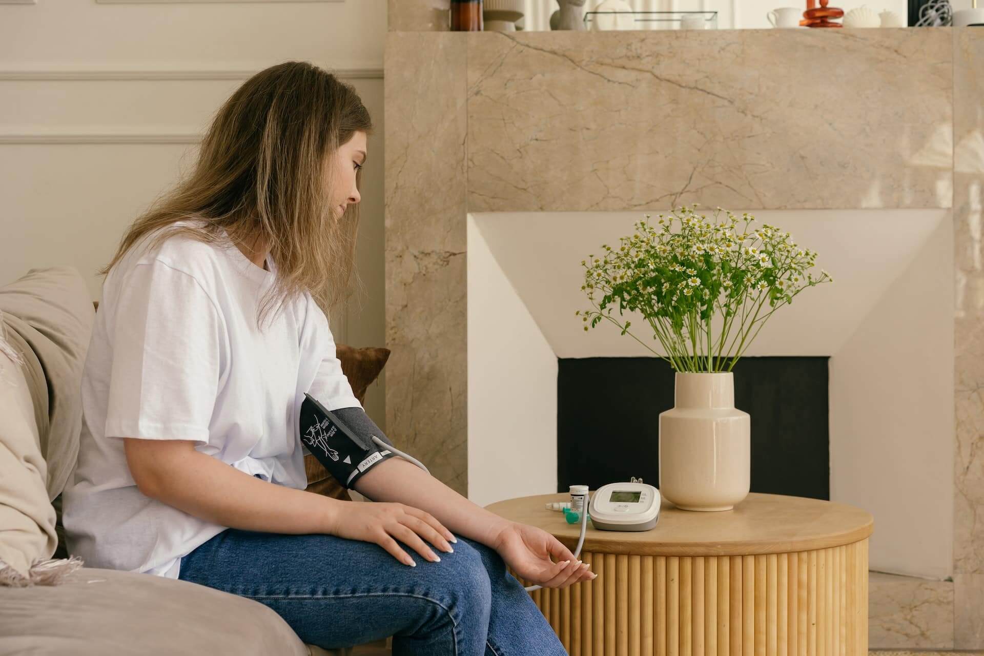 Woman-in-a-white-shirt-checking-her-blood-pressure