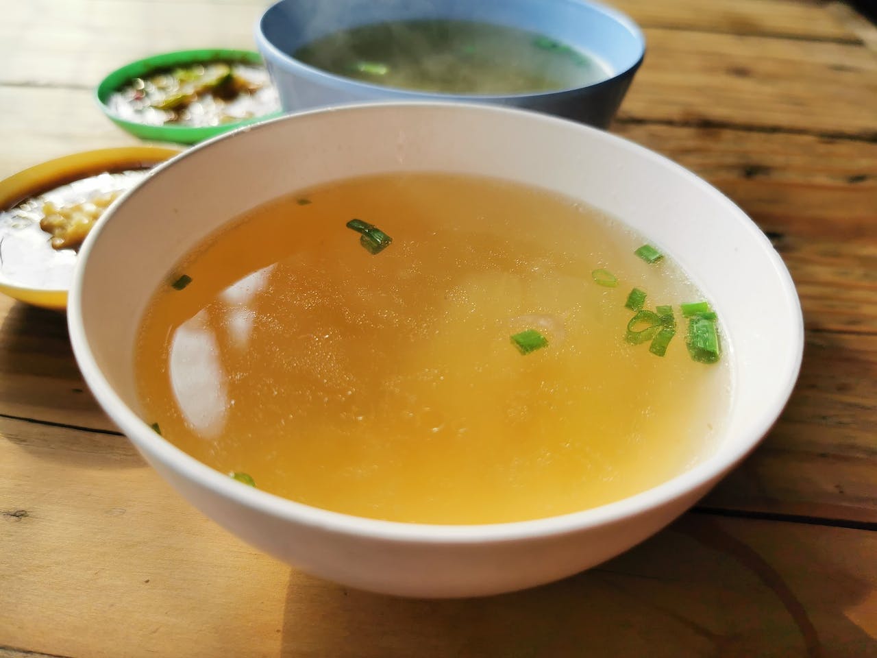 a bowl of soup in a wooden table