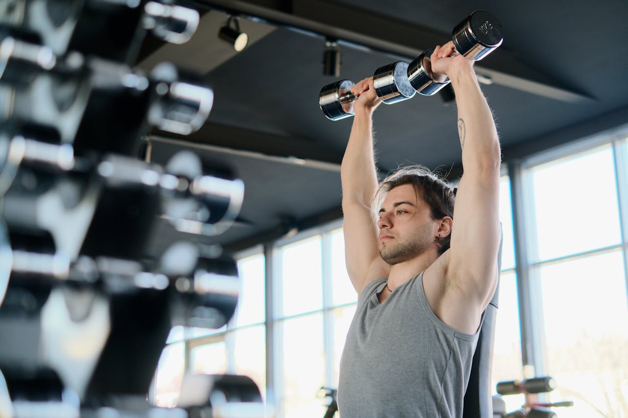 Man performing a military press at the gym.