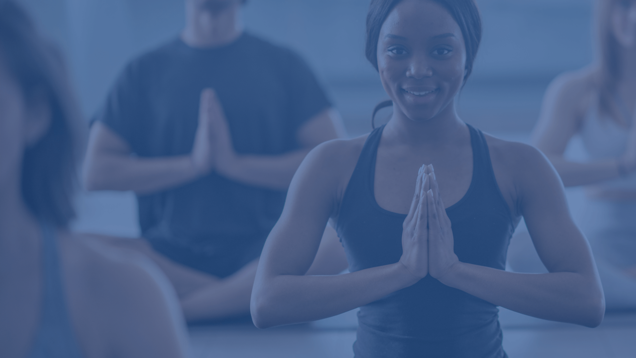 people in a yoga class with their hands in prayer